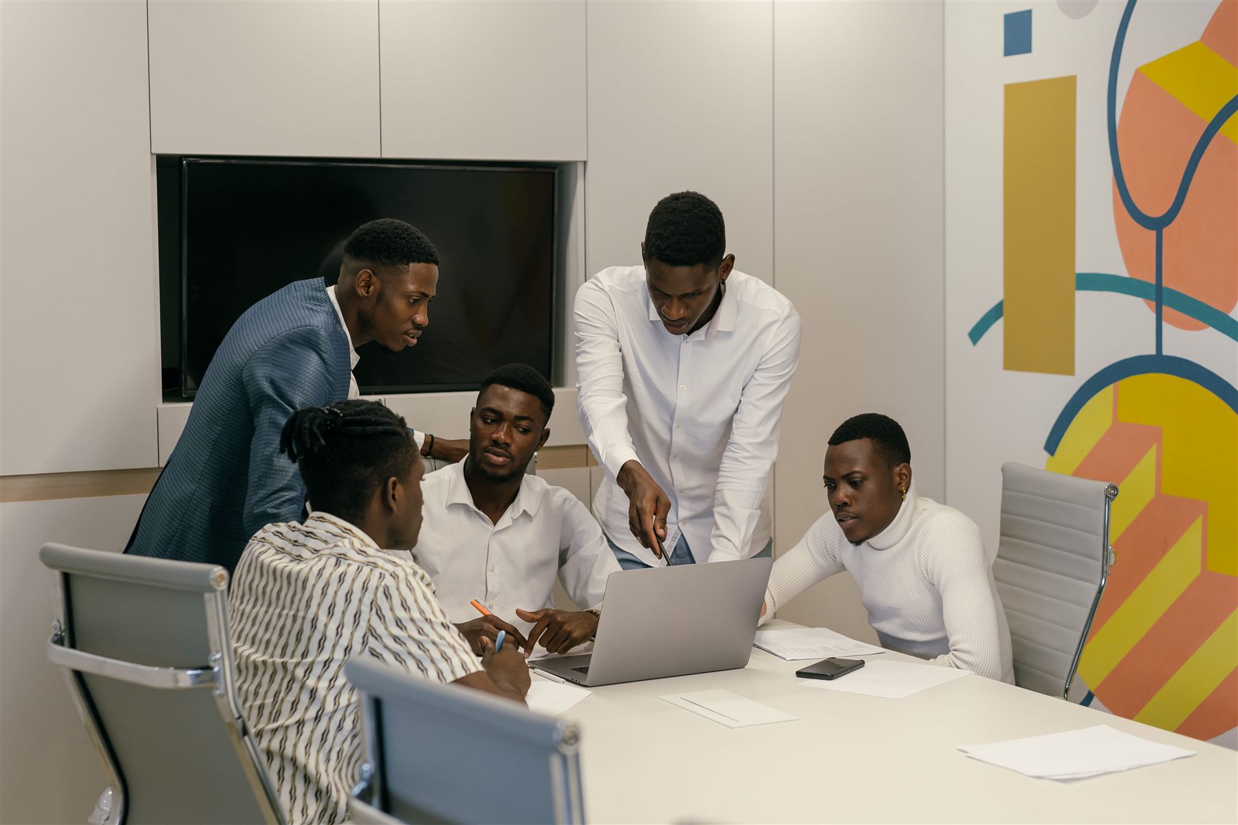A collaborative team gathered around a laptop